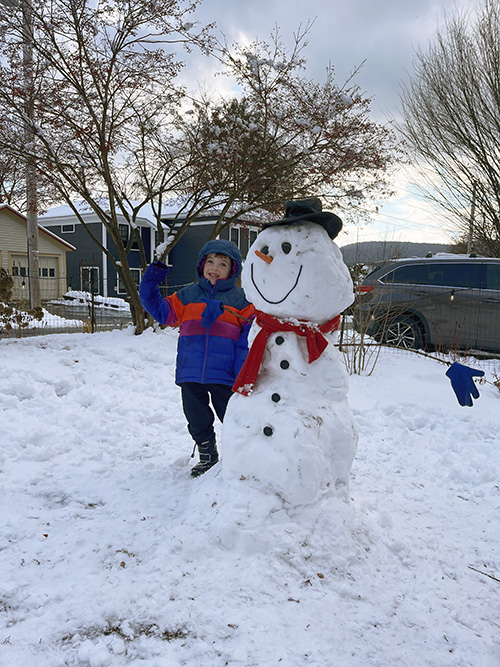 Student enjoying the snow and making snowmen